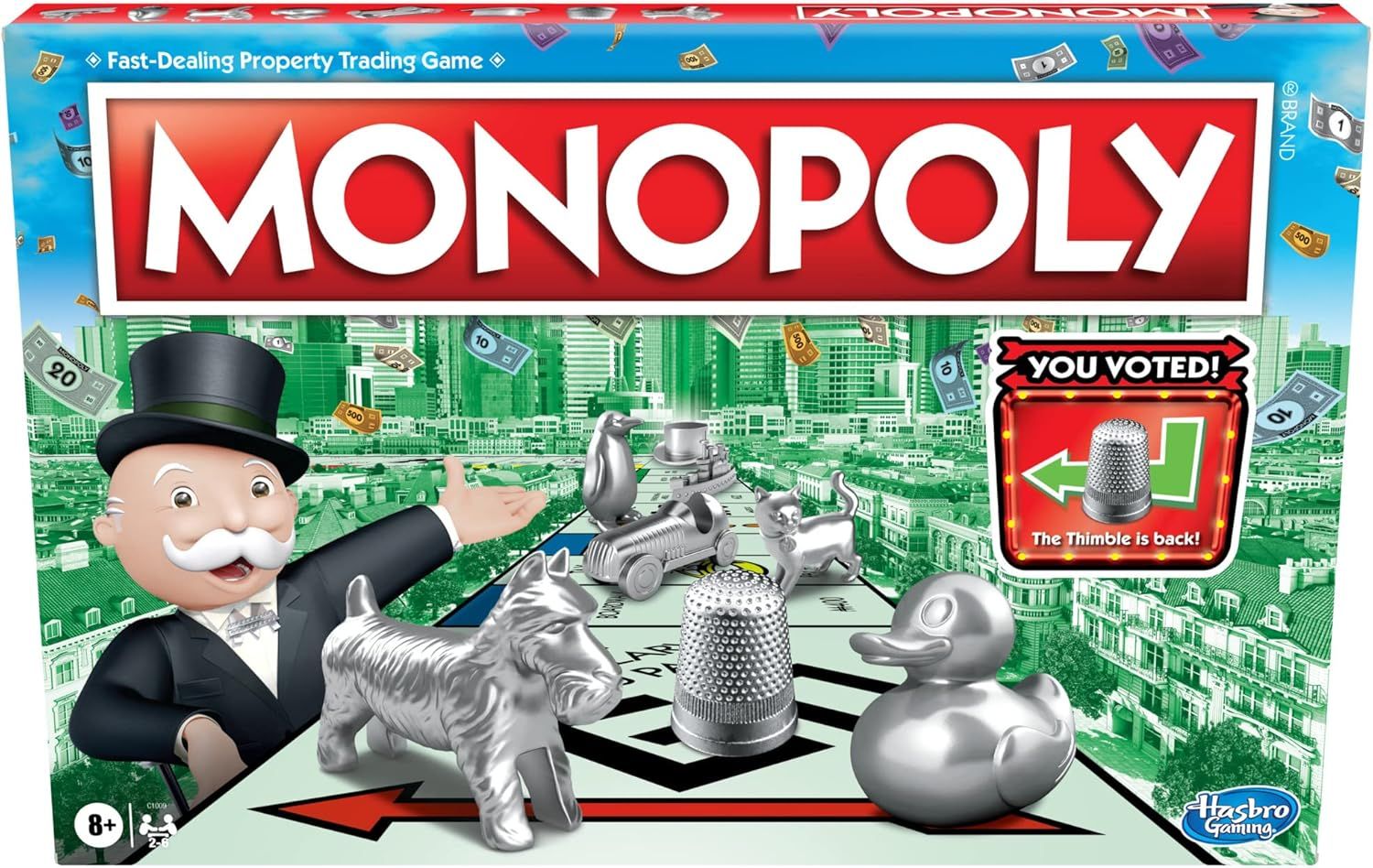 Shows the retail packaging of the Monopoly board game to help shoppers identify the product on shelf or confirm what they will receive in their delivery. Displays the iconic Monopoly game pieces…