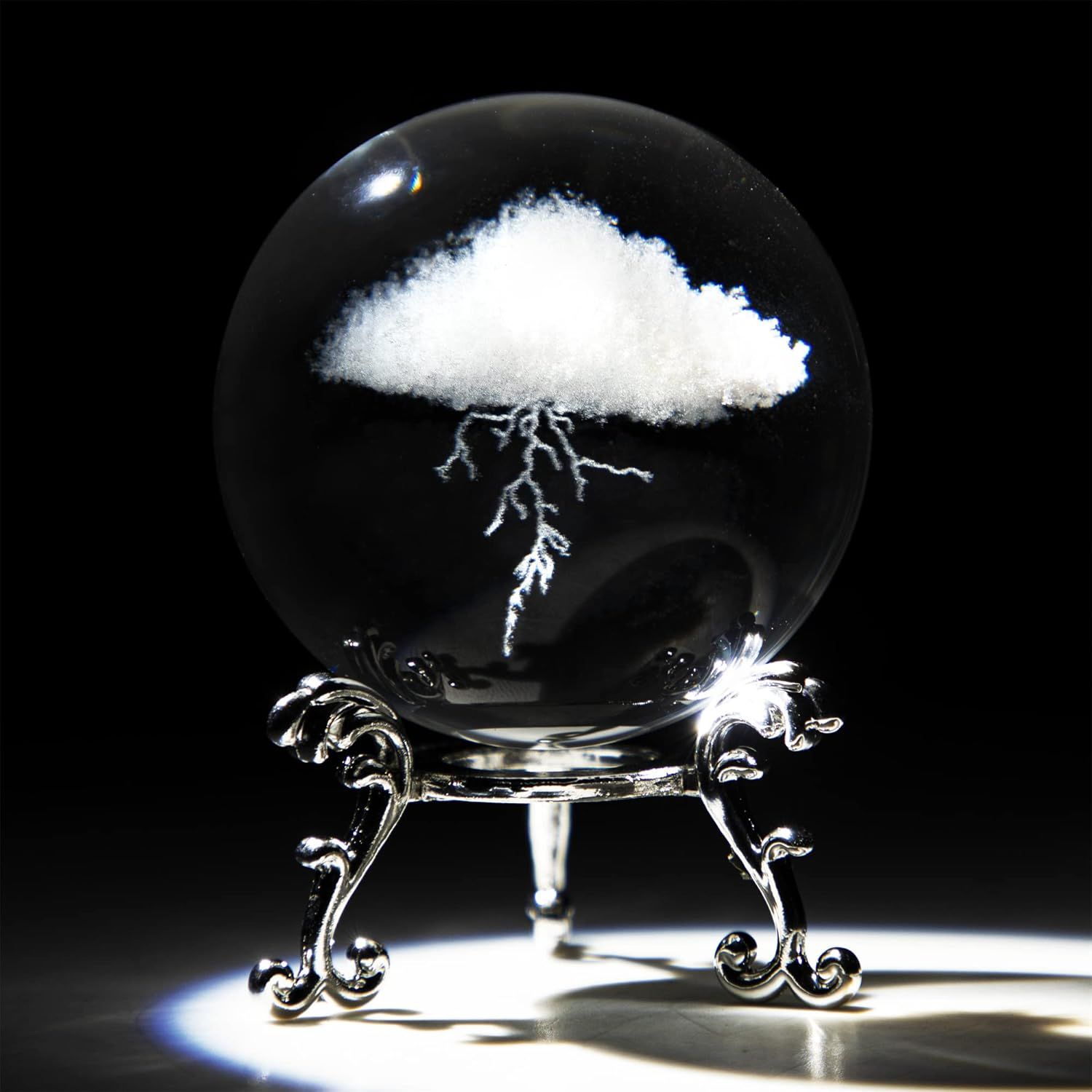 Showcases the core product, a decorative crystal sphere with an embedded cloud and lightning design, displayed on an ornate stand to communicate its artistic and collectible nature. Uses a black…