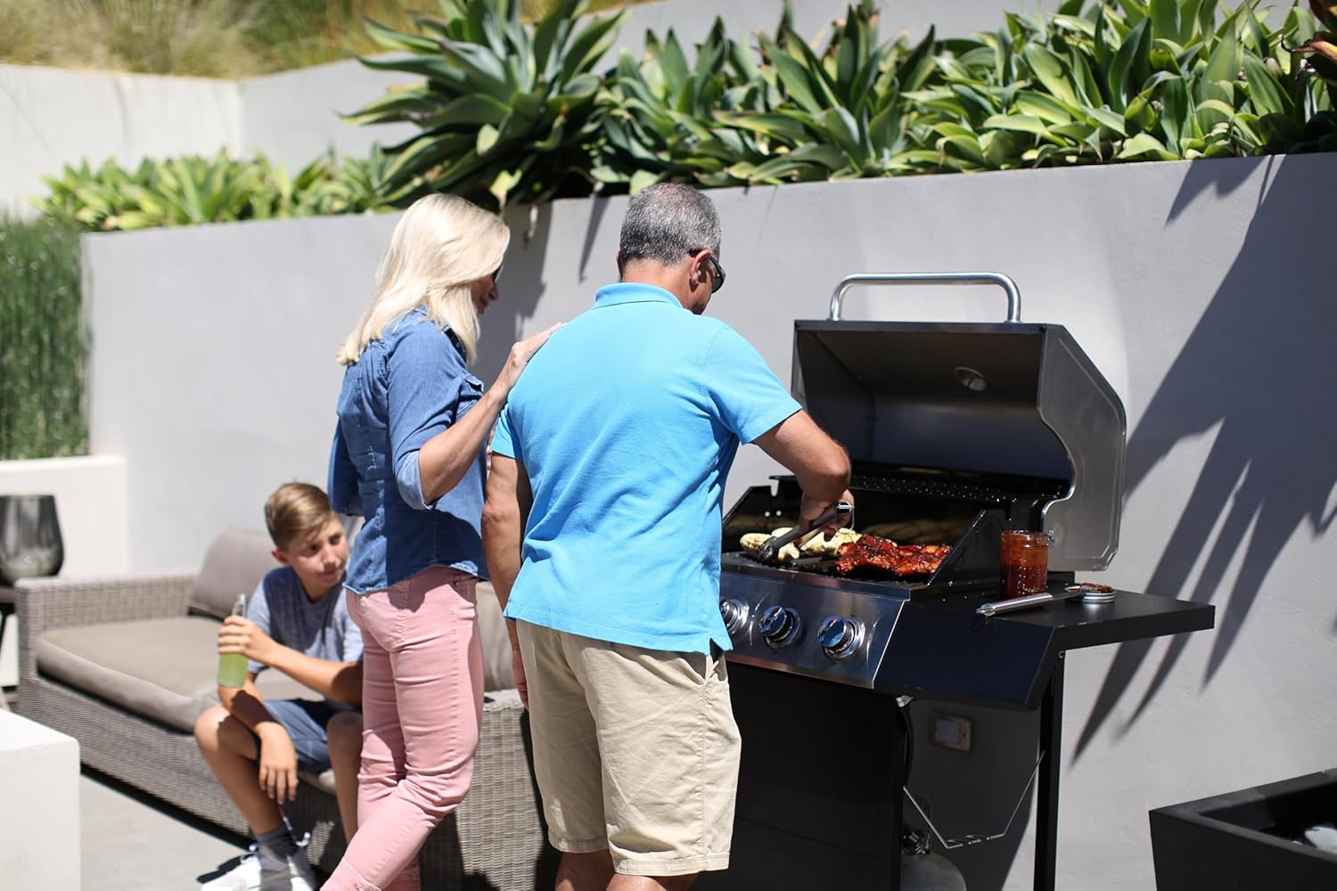 Shows the product being used in a real-world backyard setting by a family, highlighting its suitability for outdoor cooking and gatherings.