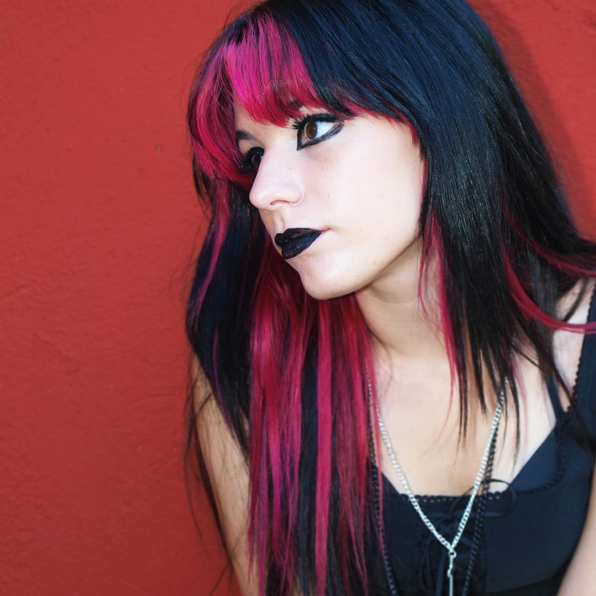 Showcases the vibrant and edgy hair coloring and makeup application, likely to appeal to customers interested in bold, alternative styles.