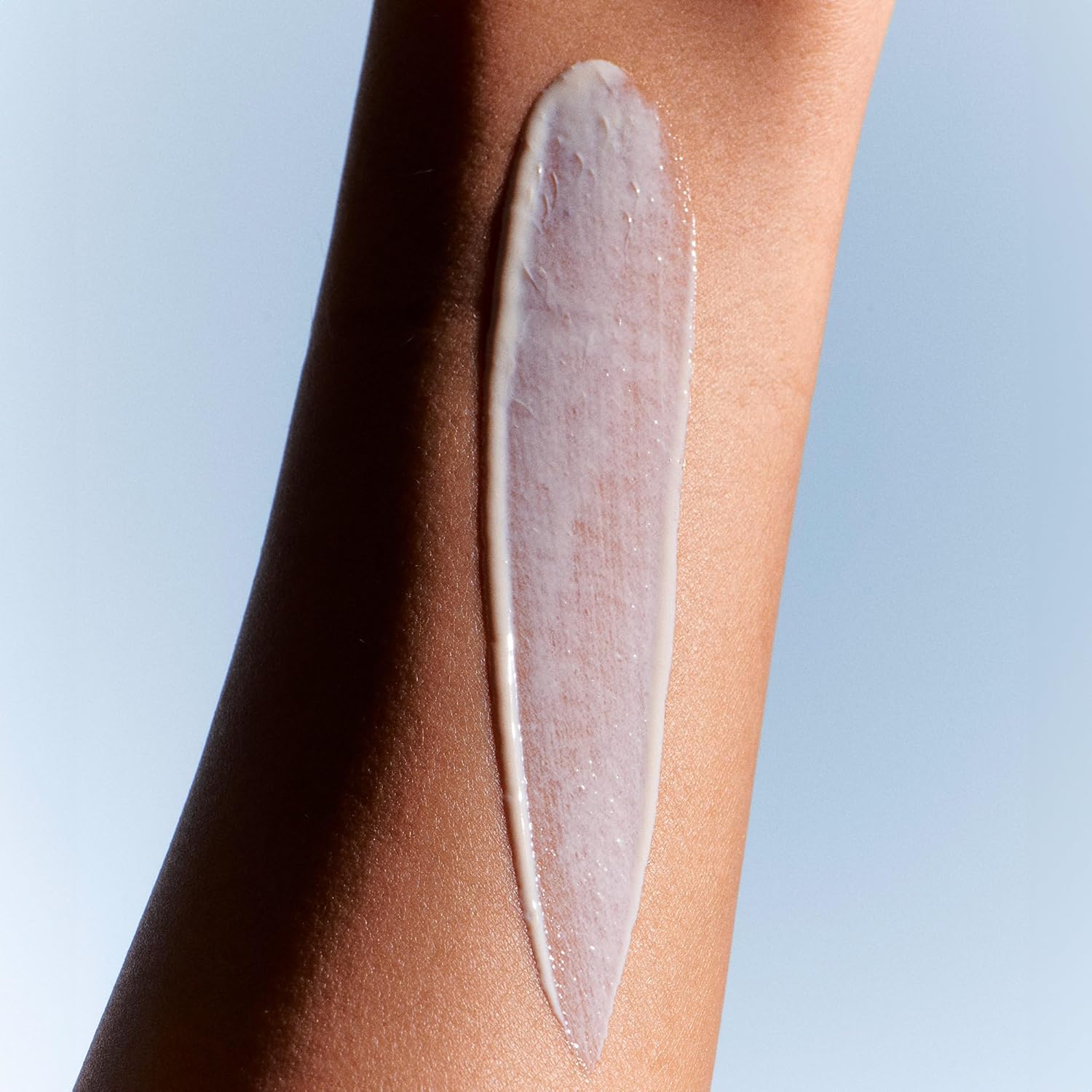 Demonstrates the product's smooth and even application on skin, highlighting its texture and coverage.