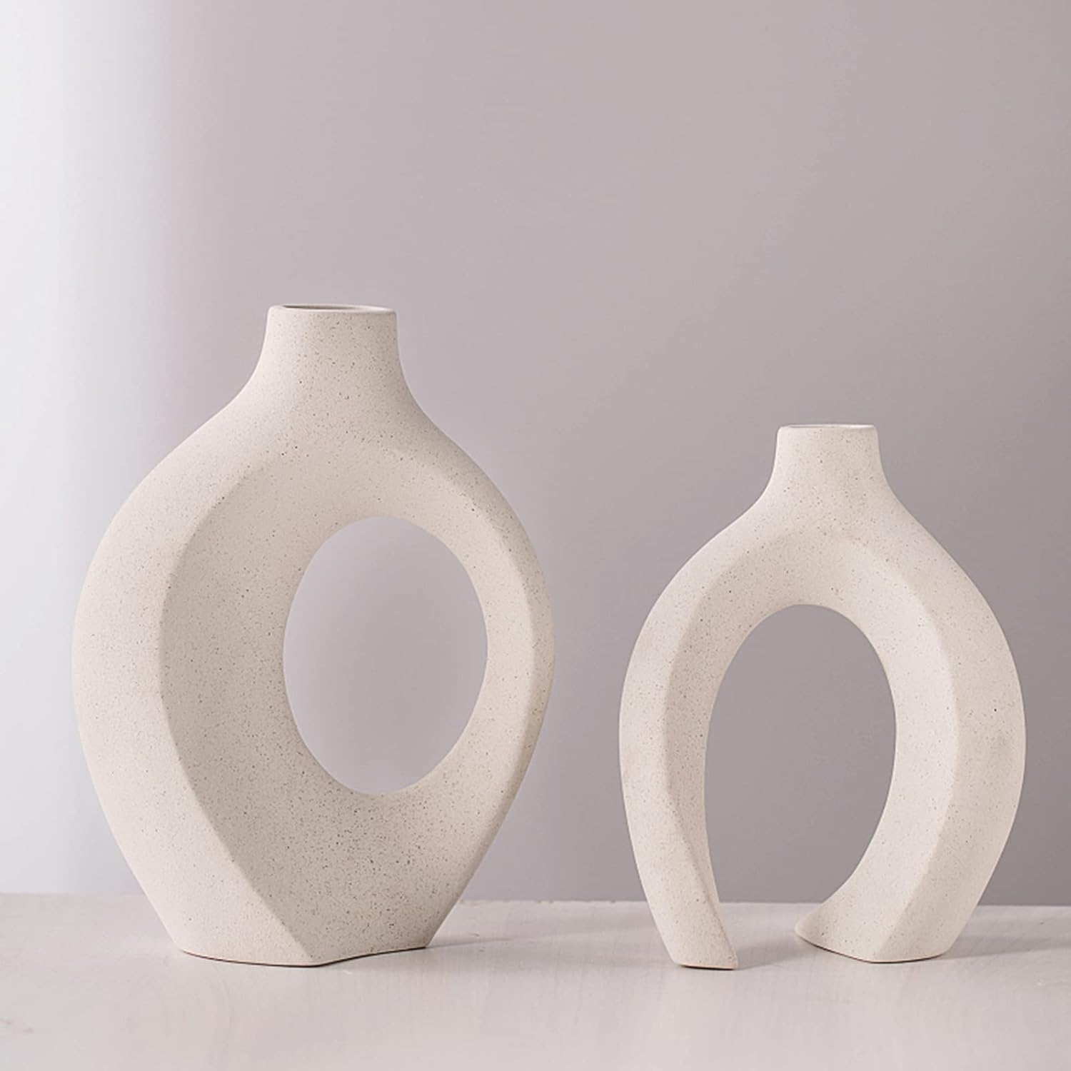 Showcases the vases in a clean, minimalist setting to highlight their unique shape and aesthetic appeal as decorative objects.