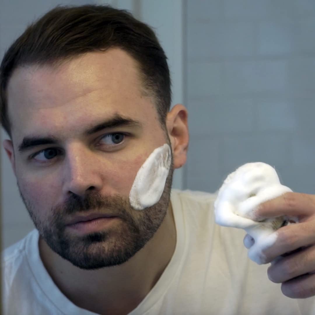 Demonstrates the proper technique for applying shaving cream to the face, helping customers understand how to use the product effectively.