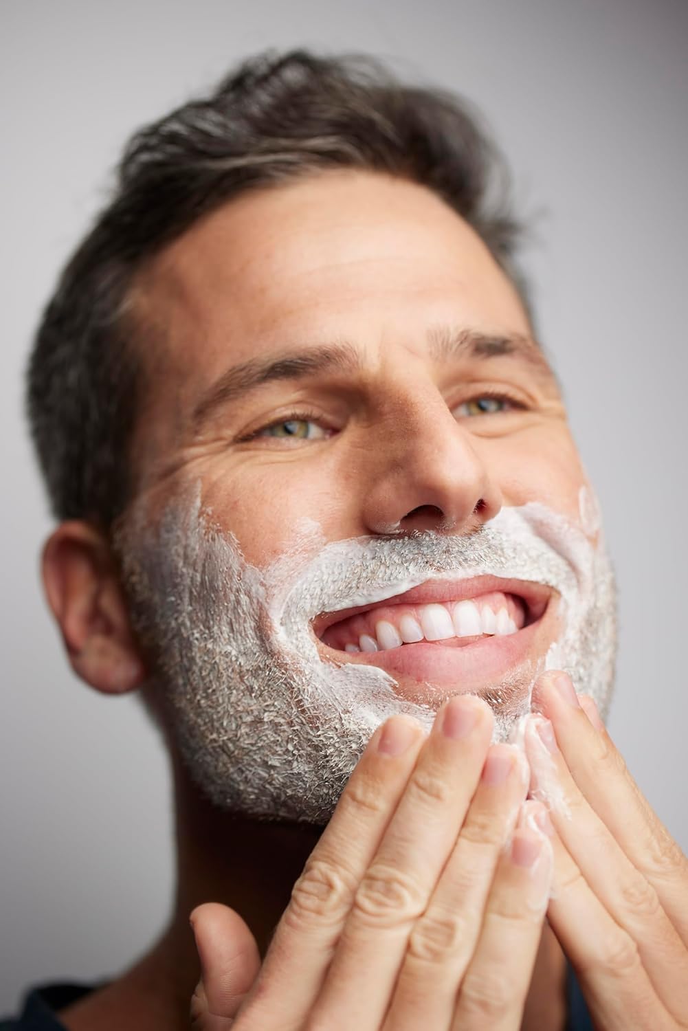 Shows a man enjoying the process of shaving, implying the product provides a pleasant and effective shaving experience.