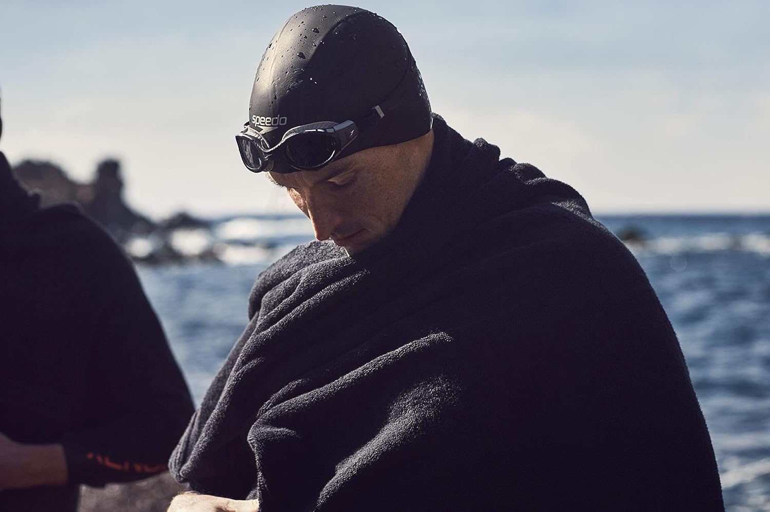 Shows the product being used in a real-world open water swimming context, emphasizing its suitability for outdoor aquatic activities.