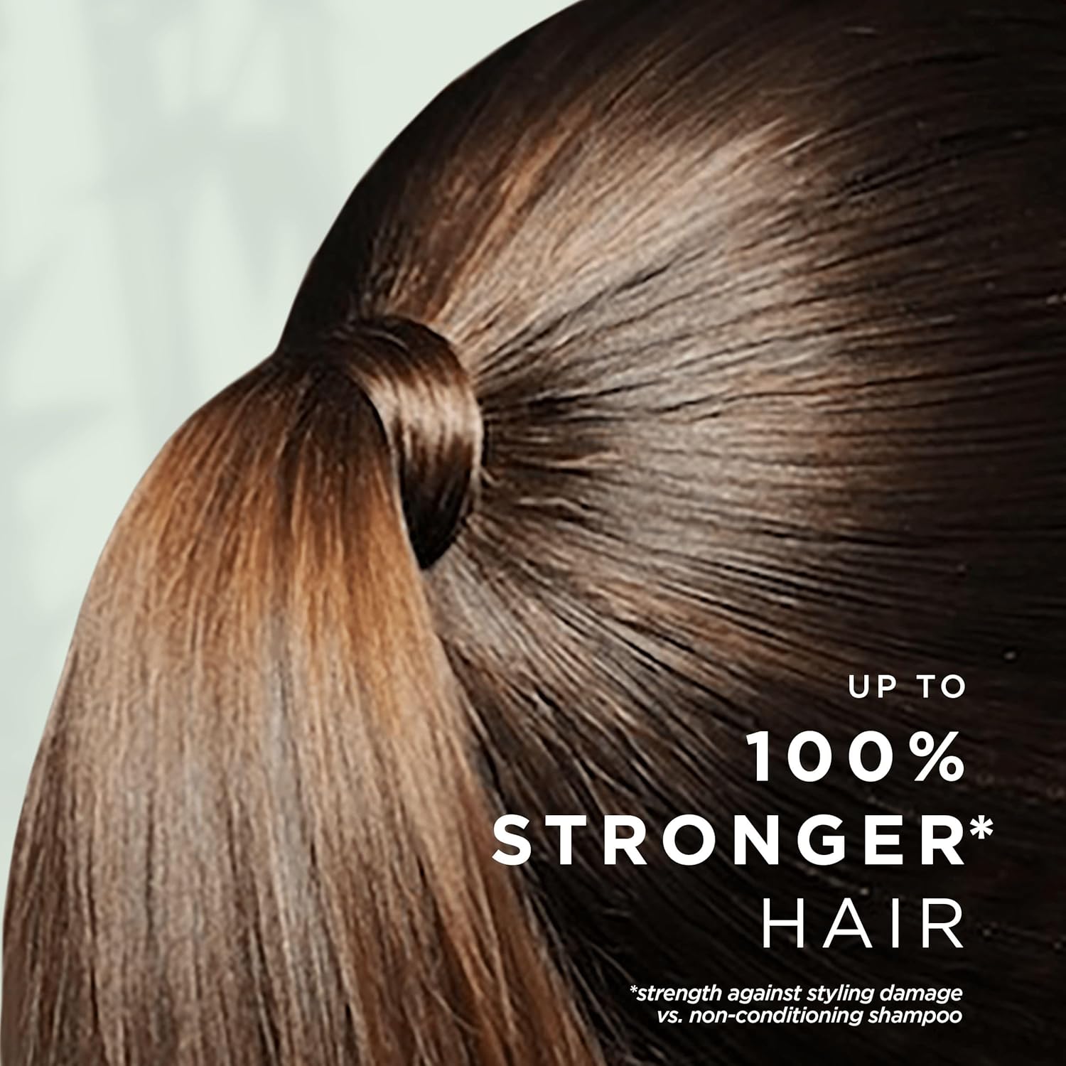 Highlights the product's ability to make hair up to 100% stronger against styling damage compared to non-conditioning shampoo.
