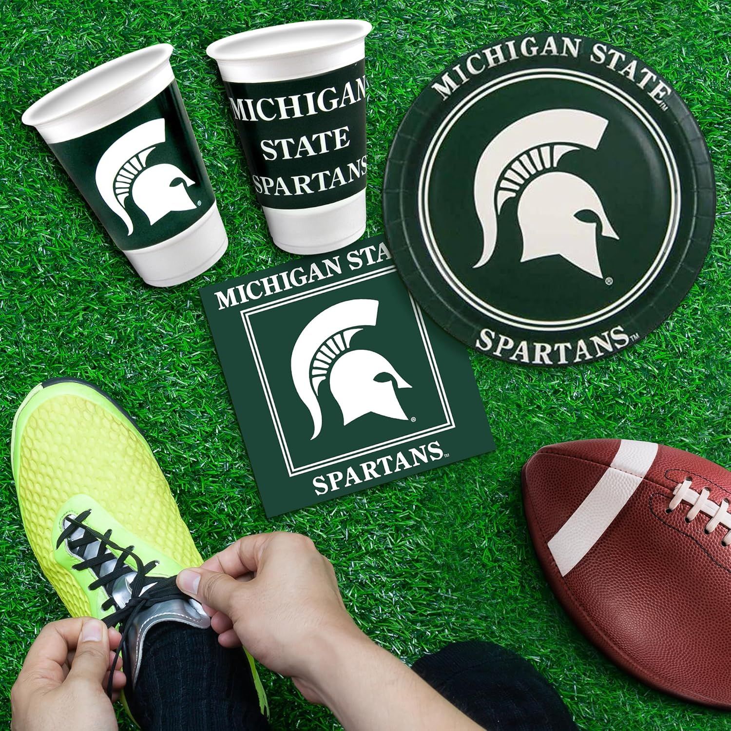 Shows all the Michigan State Spartans branded items included in the party pack, such as cups, plates, and napkins, to help shoppers understand what they receive with their purchase.