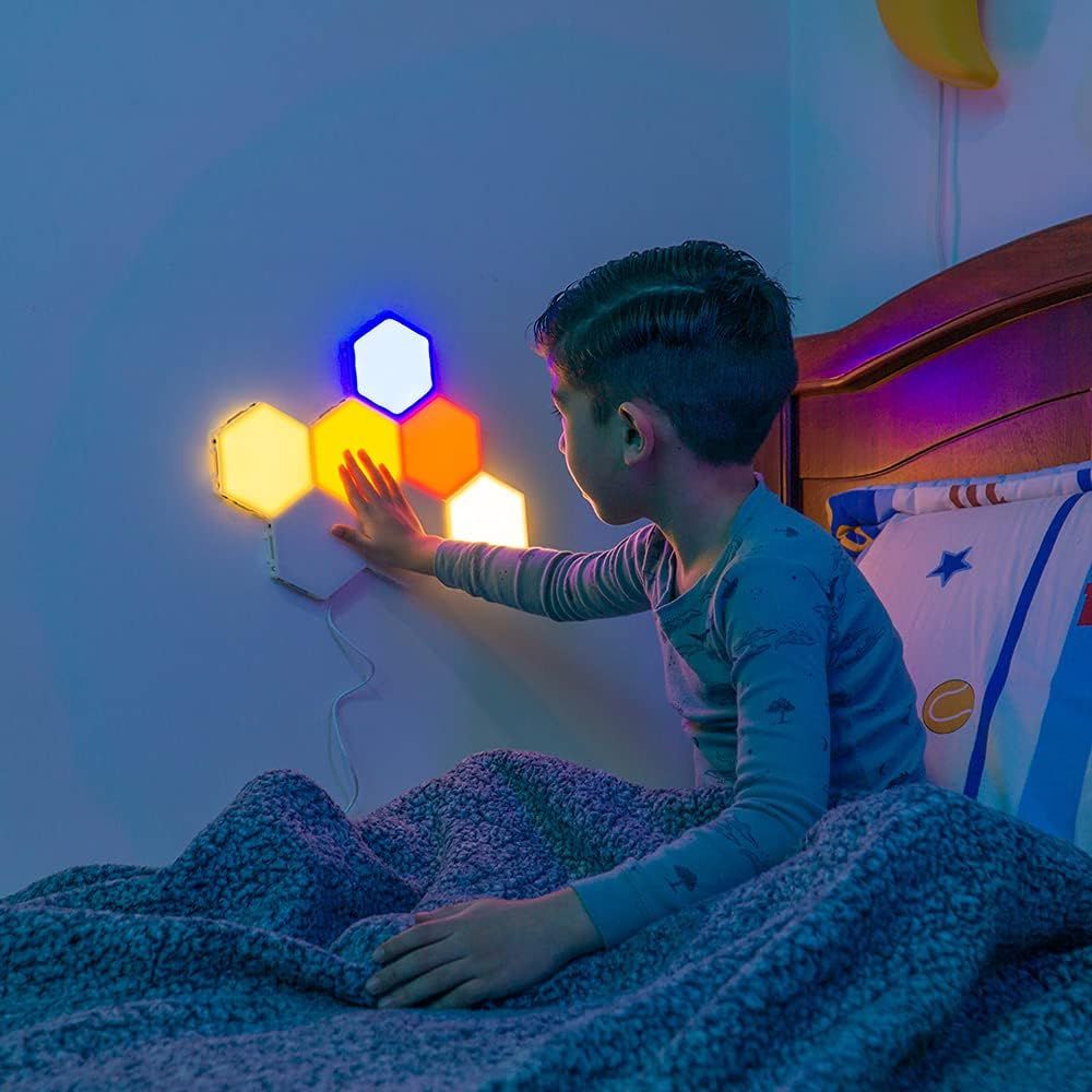 Shows the product being used in a real-world bedroom environment by a child, demonstrating its interactive touch functionality and ambient lighting effect to help shoppers visualize how it fits into…