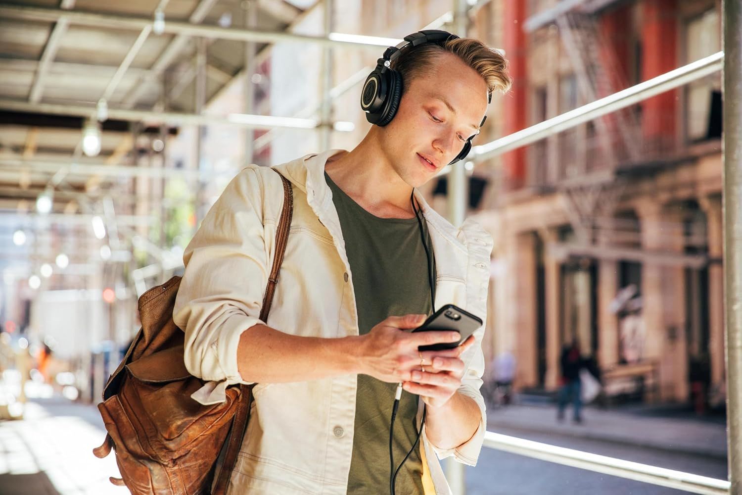 Shows the product being used naturally in an everyday context to help shoppers visualize how they would use the headphones during their daily commute or travel.