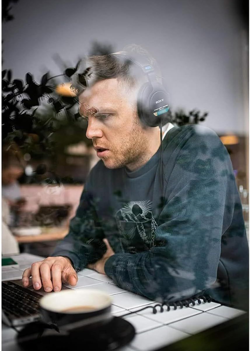 Shows the product being used in an authentic work-from-home or office environment to help shoppers visualize how the headphones fit into their daily routine.