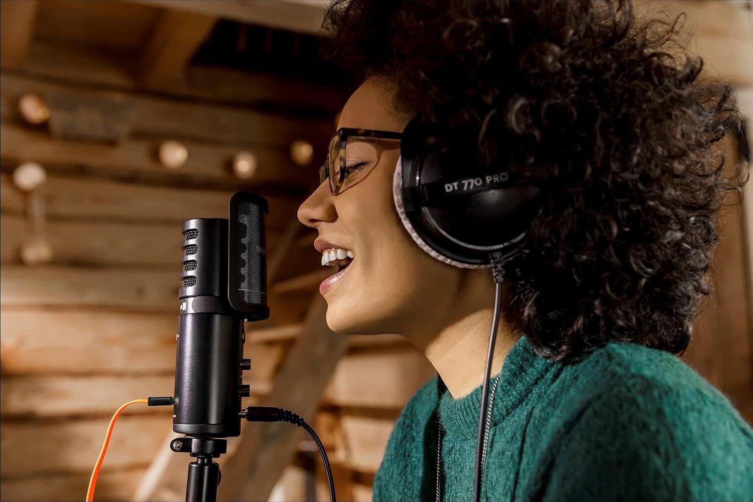 Shows the product being used in a real-world recording studio environment to help shoppers visualize how the microphone and headphones work together during vocal recording sessions.