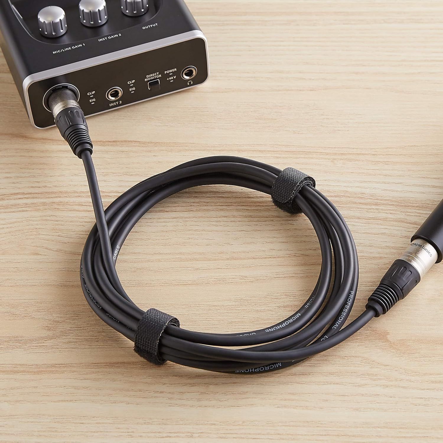 Demonstrates the cable's built-in velcro straps that keep the microphone cable organized and tangle-free during storage or transport.