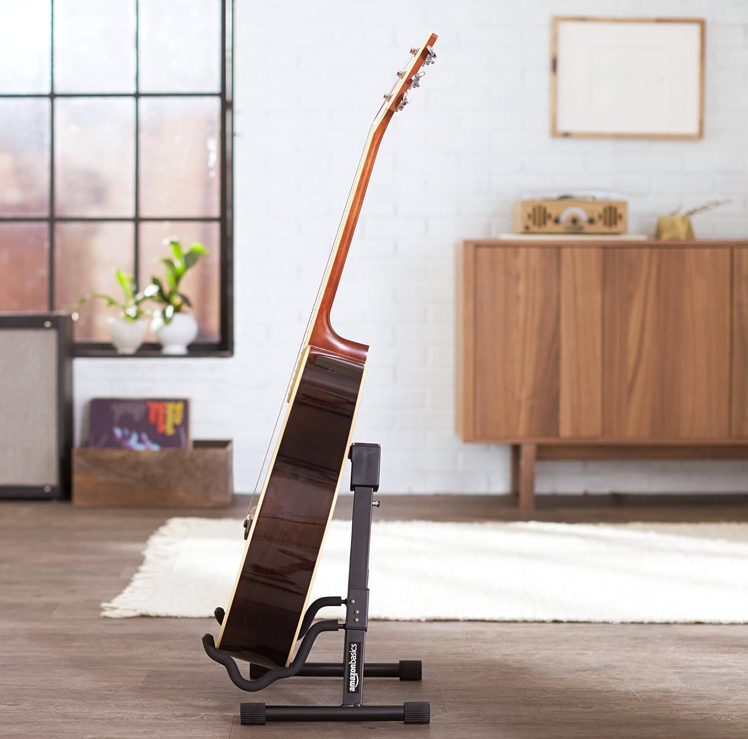 Shows the guitar stand in a real-world home setting to help shoppers visualize how the product fits into their living space and complements their decor.