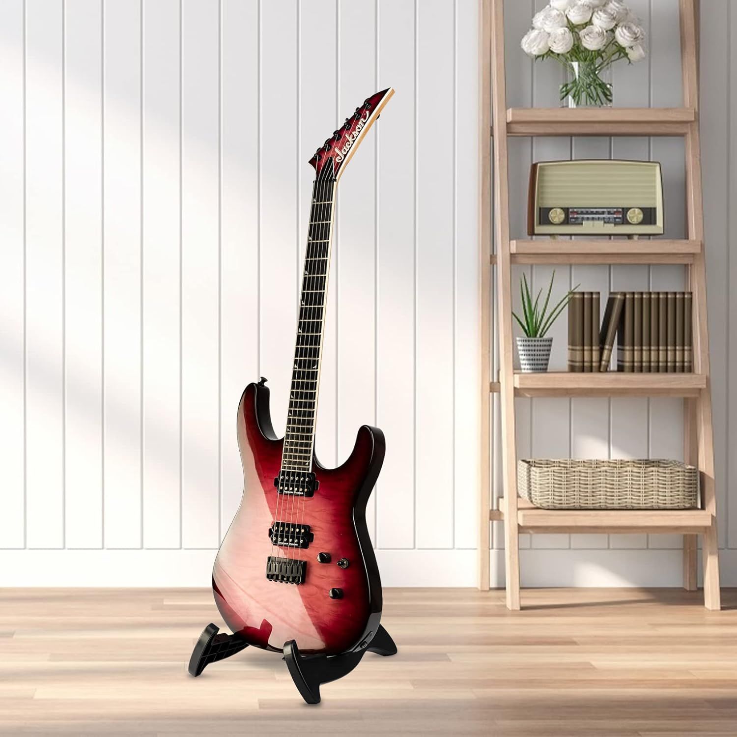 Shows the electric guitar displayed on a stand in a real-world home setting to help shoppers visualize how the product looks when not in use and how it fits into their living space.