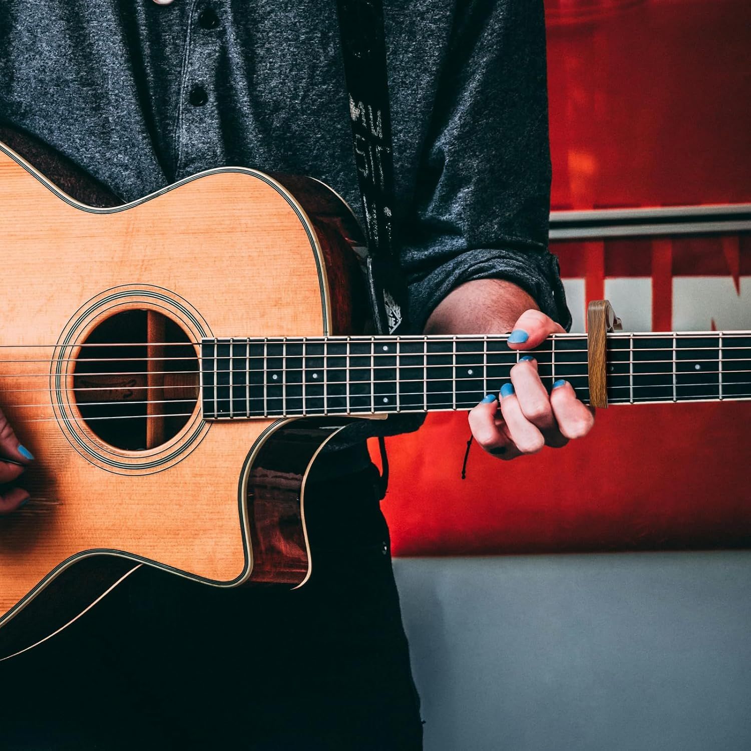 Shows the guitar being played in a natural, real-world setting to help shoppers visualize themselves using the product and connect emotionally with it.