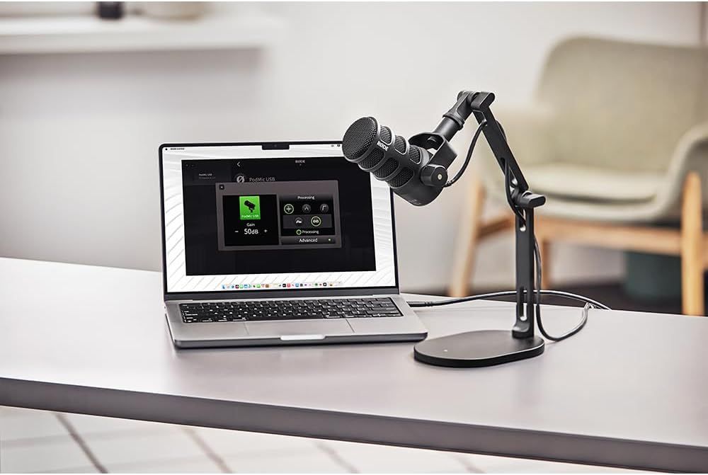 Shows the microphone in a real-world podcasting or streaming setup with a laptop to help shoppers visualize how the product fits into their workspace.