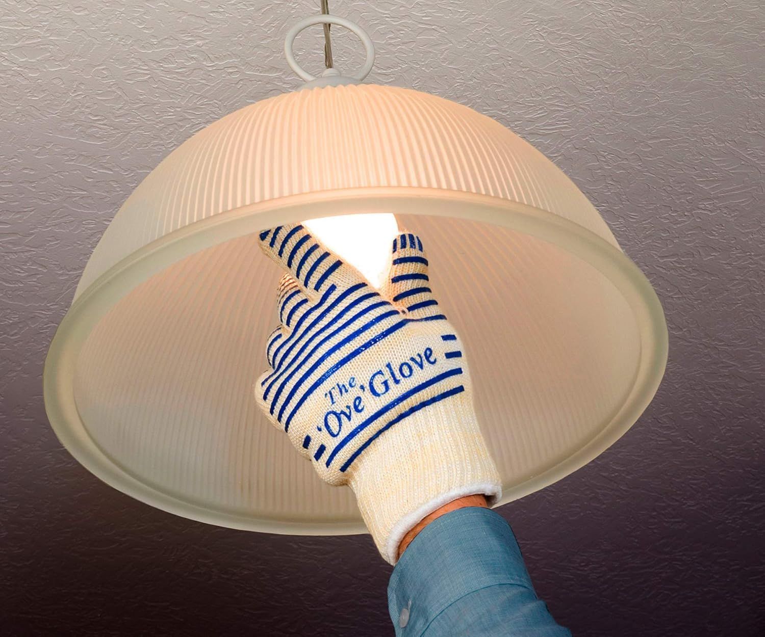 Demonstrates that the glove can safely handle hot objects like light bulbs without burning the user, reassuring shoppers of its heat protection capability.