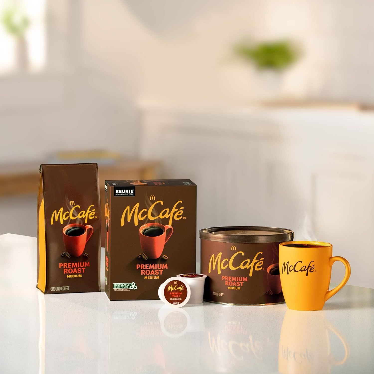Shows the variety of McCafe Premium Roast coffee formats available including ground coffee bag, K-Cup box, canister, individual K-Cup pod, and branded mug to demonstrate purchasing options.