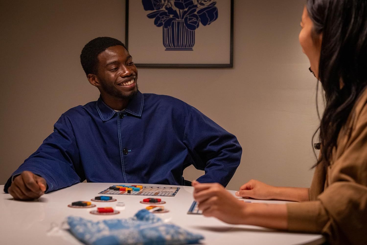 Demonstrates the product being enjoyed in a real-world social setting, showing two people engaged and happy while playing together, which communicates the product's ability to bring people together…