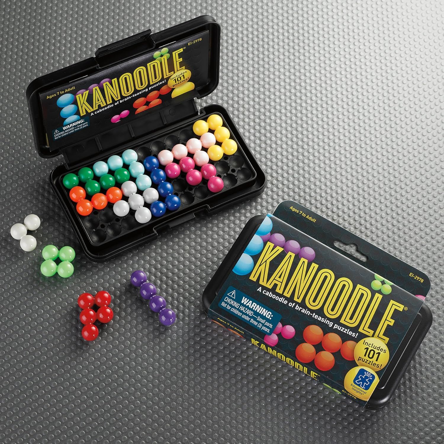 Shows everything included in the package—the puzzle pieces in multiple colors, the storage case, and the puzzle booklet—to help shoppers understand the complete contents and value of the purchase.