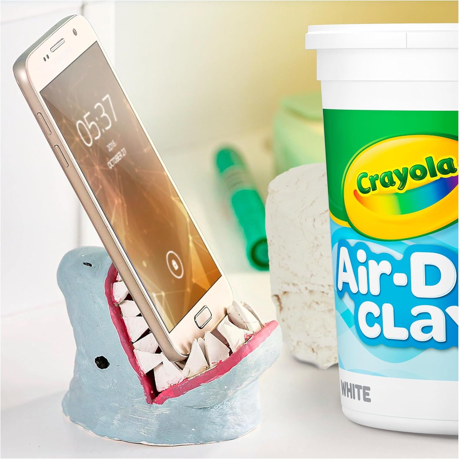 Demonstrates a creative DIY application showing how the product (Air-Dry Clay) can be used to make a functional phone stand, inspiring shoppers with a practical craft idea. Shows one of the many…