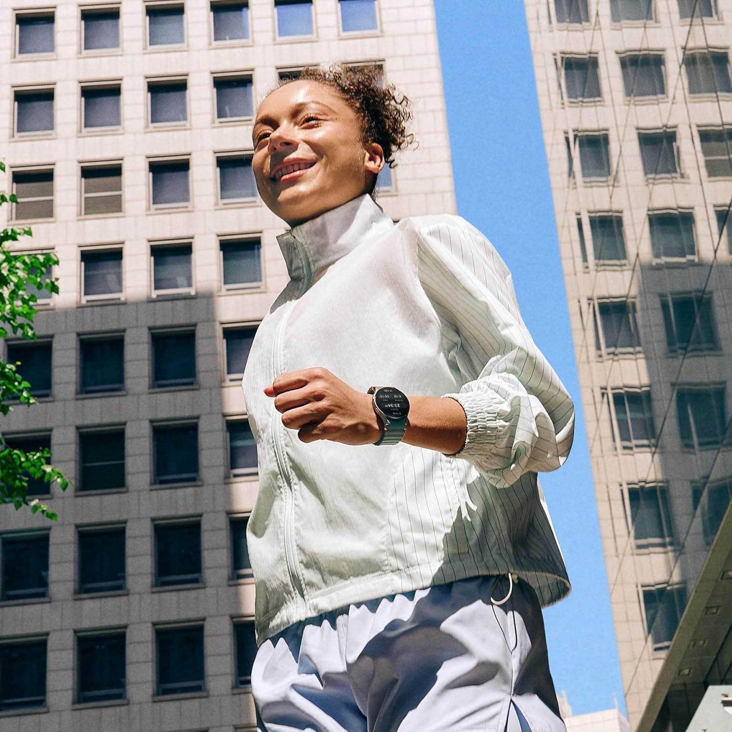 Demonstrates the product (smartwatch) in a real-world active lifestyle context, showing it being worn during outdoor exercise in an urban environment to help shoppers visualize everyday use.