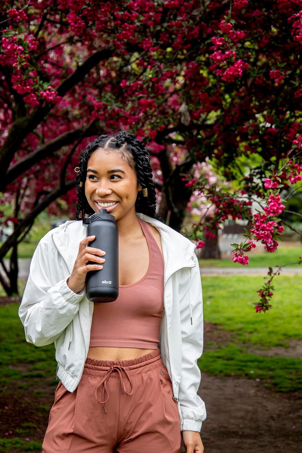 Demonstrates the product being used in a real-world outdoor setting to help shoppers visualize the water bottle as part of an active, healthy lifestyle.