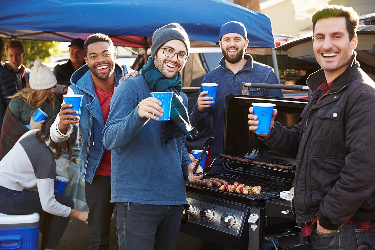 Showcases the product in a real-world tailgating or outdoor party setting to help shoppers visualize using it for social gatherings and entertaining.