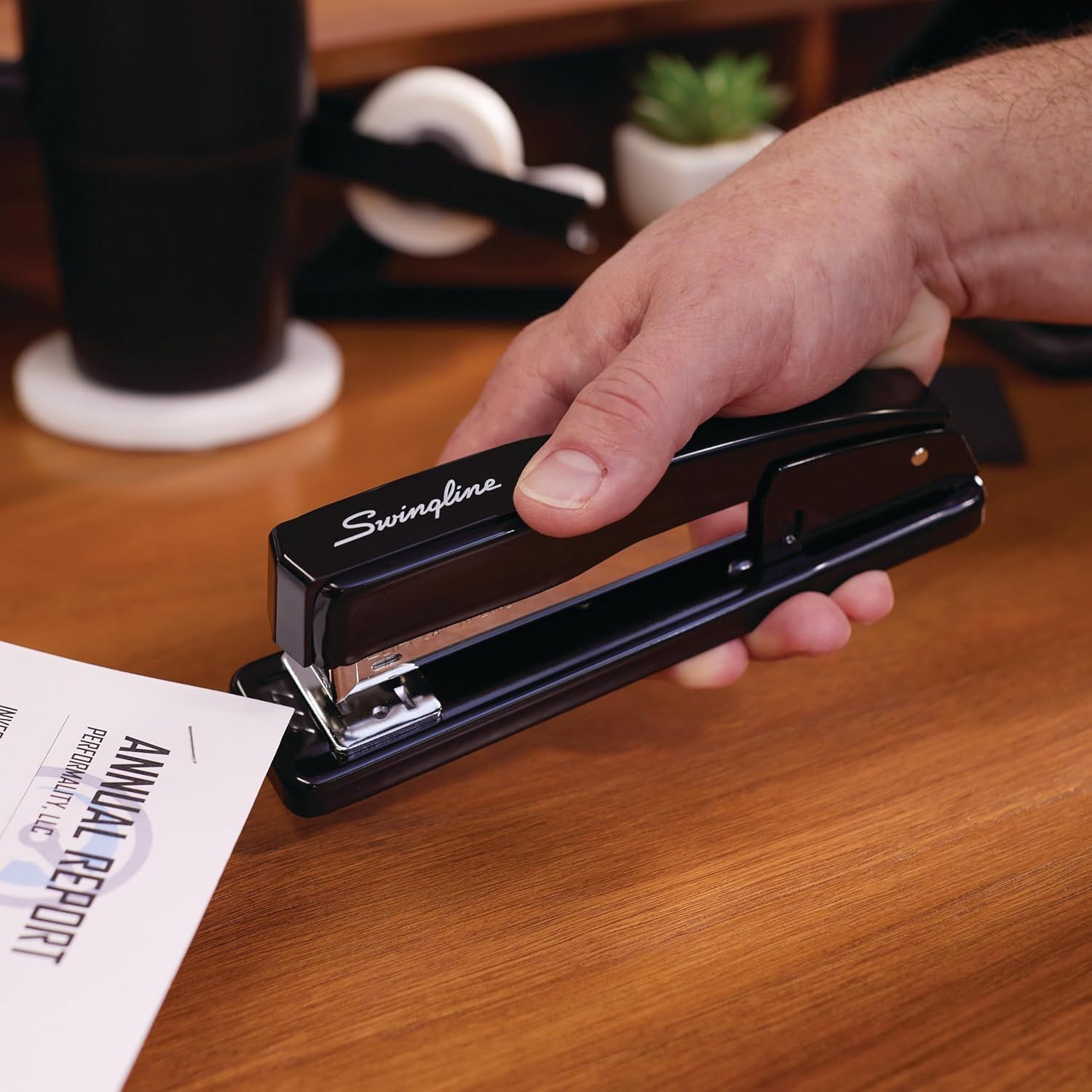 Demonstrates the product in a natural office setting to help shoppers visualize how the stapler fits into their everyday work environment.