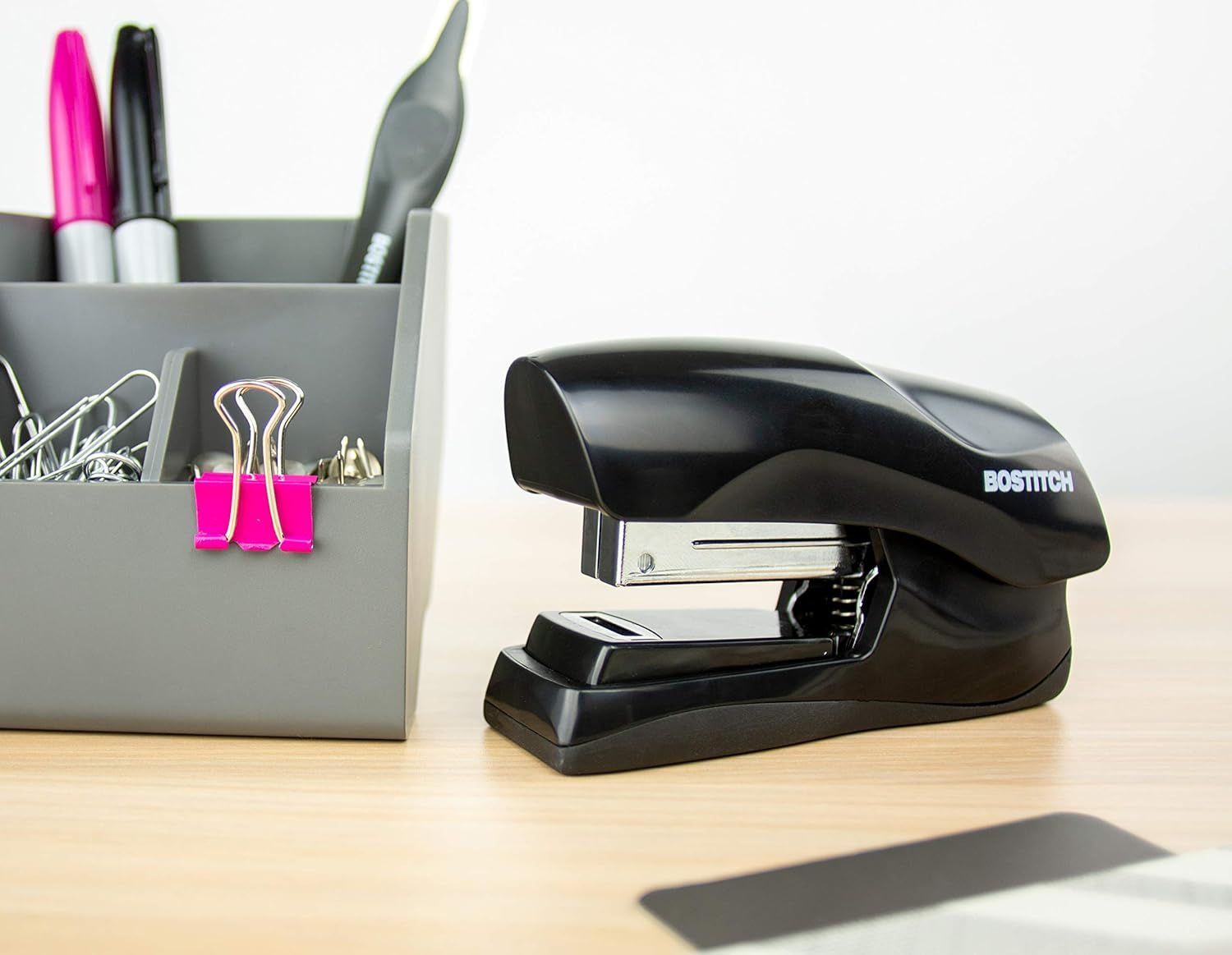 Shows the stapler in a real-world office setting to help shoppers visualize how it fits naturally on a desk alongside other office supplies.
