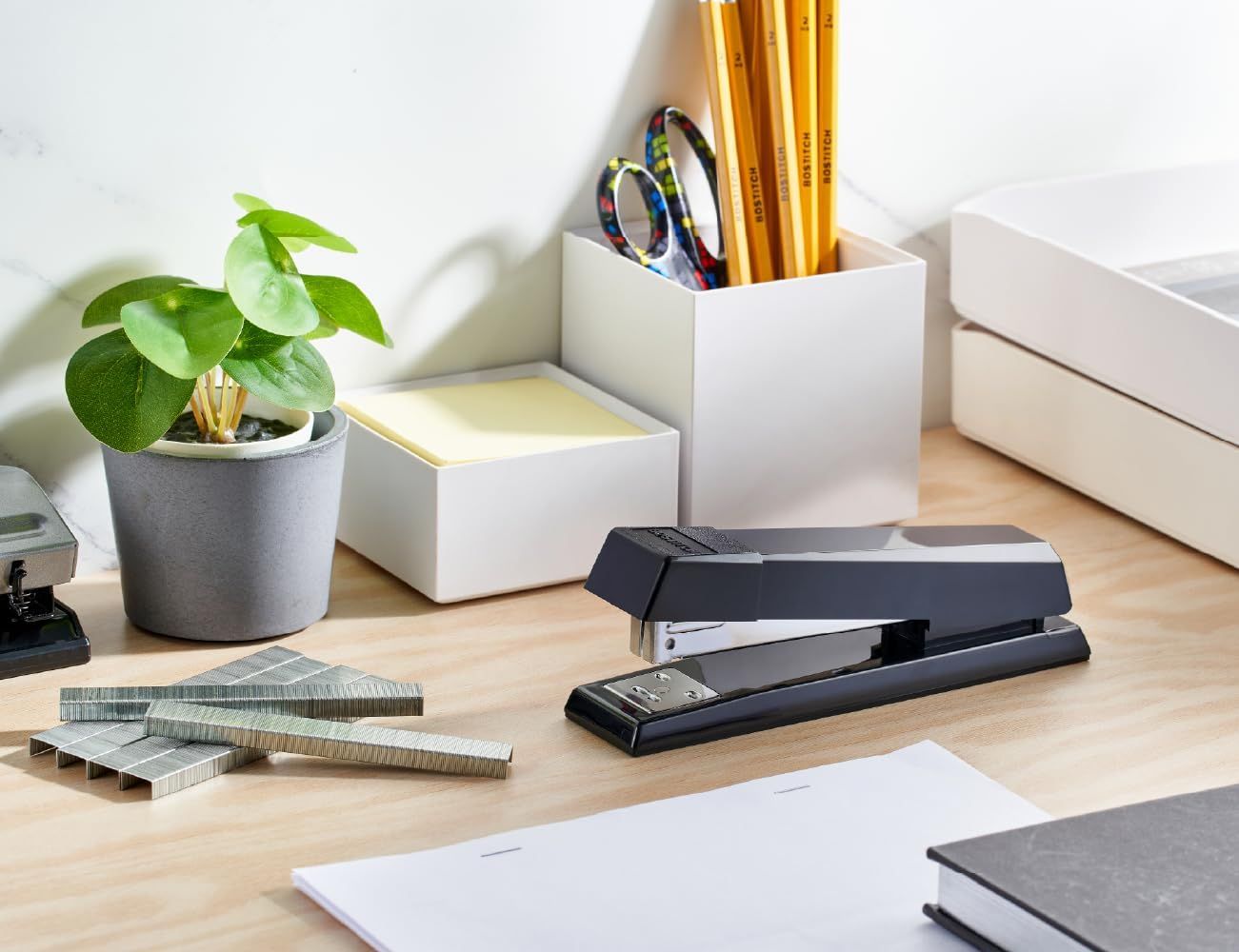 Demonstrates the product in a real-world office setting to help shoppers visualize how the stapler fits naturally into their workspace.