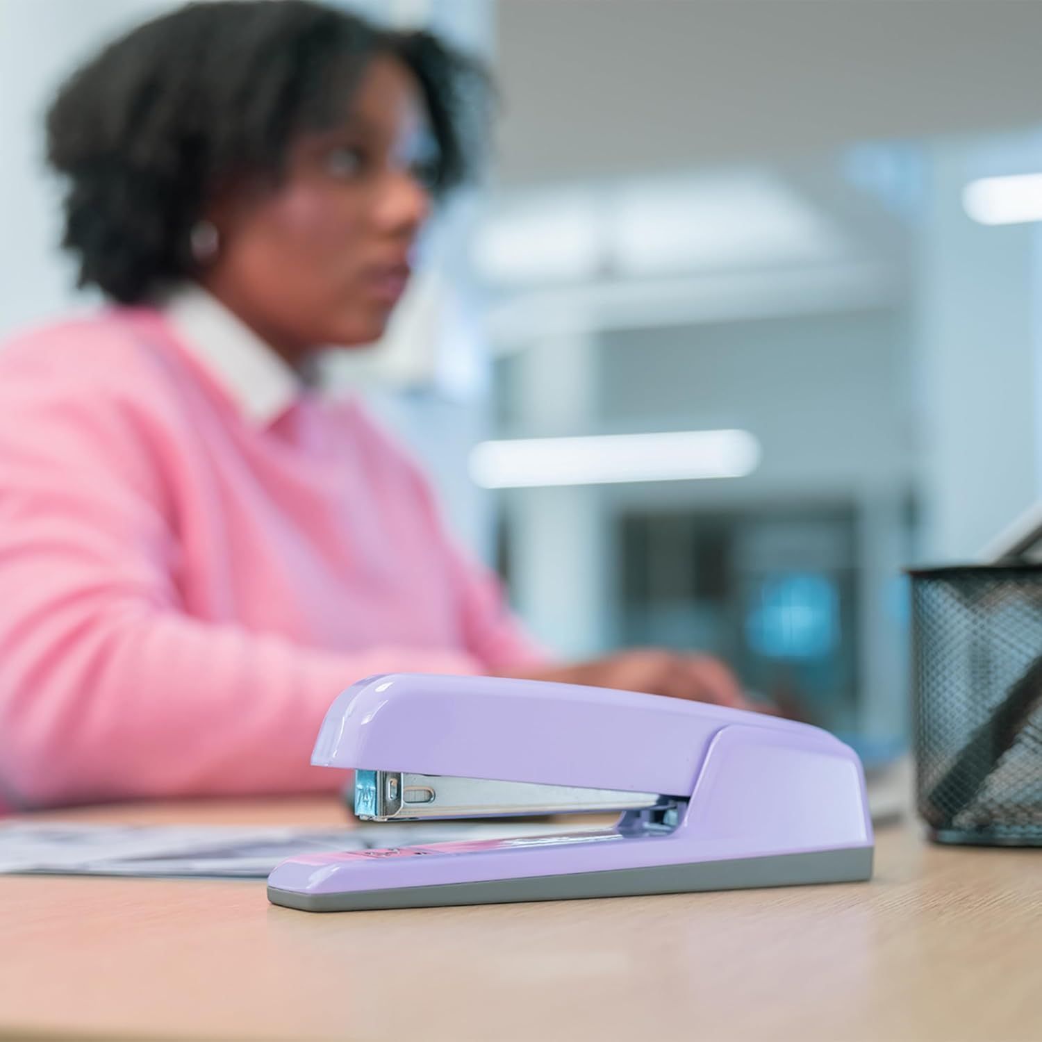 Demonstrates the product in a real office environment to help shoppers visualize how the stapler fits naturally into their workspace.
