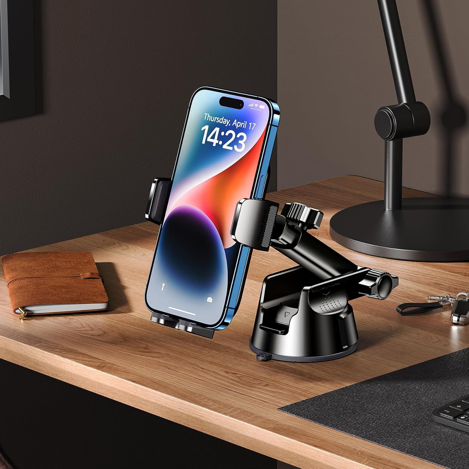 Demonstrates the product in a real-world office or home workspace setting to help shoppers visualize how the phone mount fits into their daily environment.