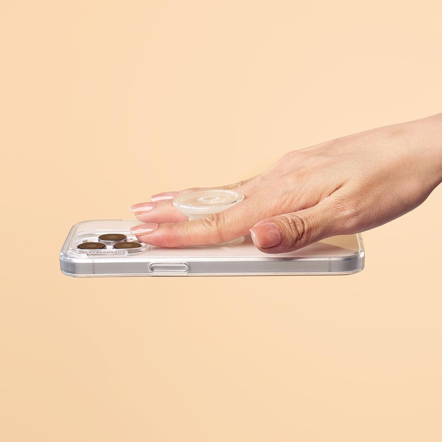 Demonstrates the product in a real-world usage scenario, showing a hand interacting with a clear phone case with an integrated ring holder, helping shoppers visualize how the product looks and…