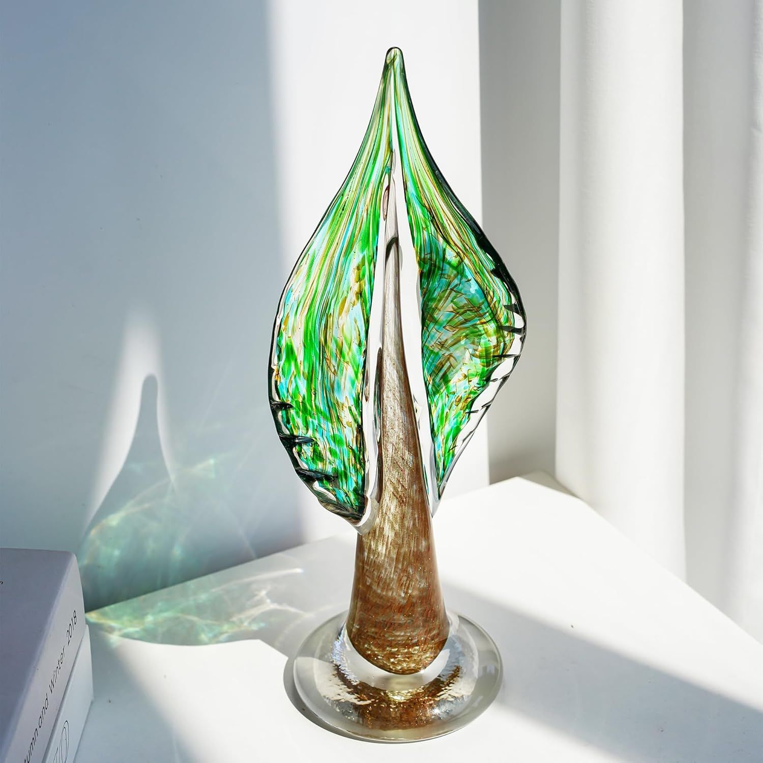 Shows the product in a real-world home setting to help shoppers visualize how the decorative glass art piece would look displayed in their own space.