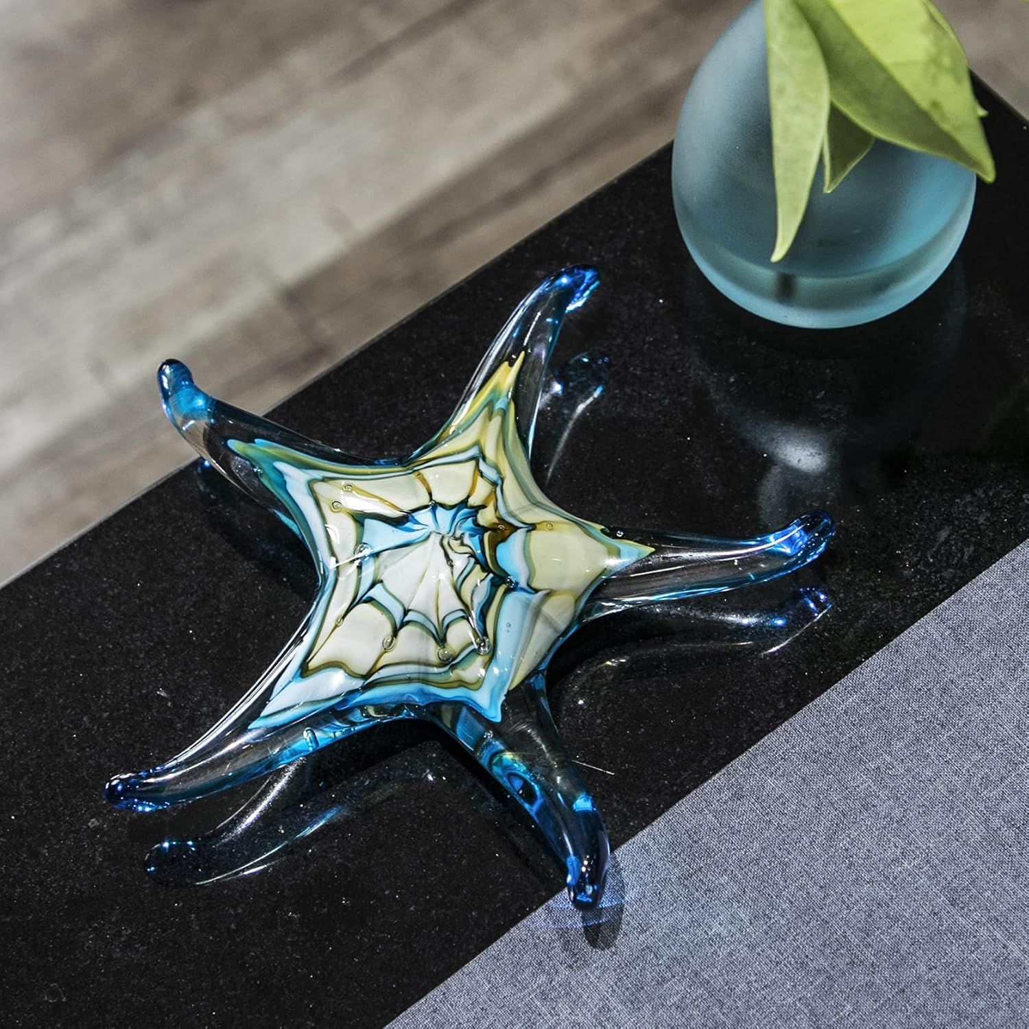 Showcases the product in a real-world home setting to help shoppers visualize how the decorative glass piece would look styled in their own space.
