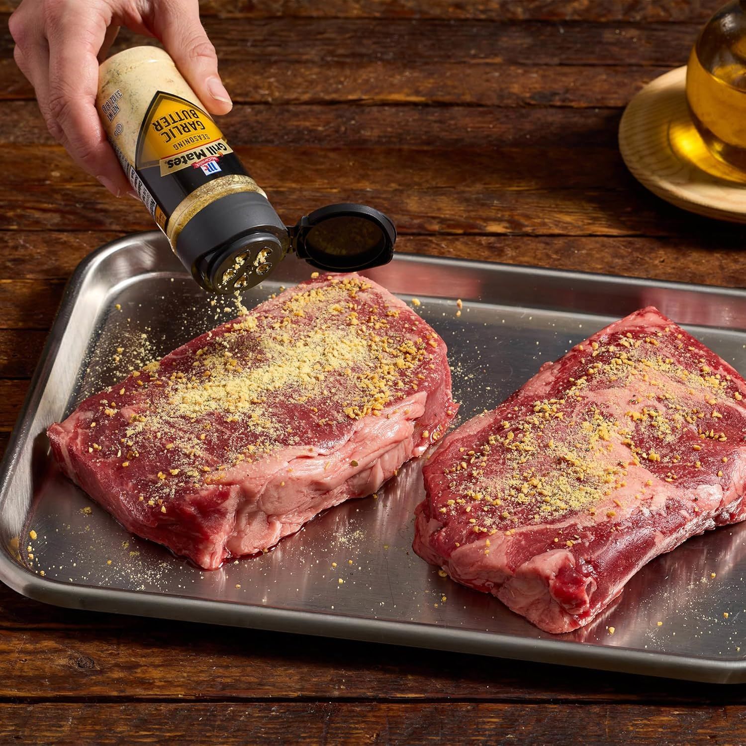 Demonstrates how to use the garlic butter seasoning product by showing it being applied to raw steaks, illustrating a practical cooking application. Shows the product in action to communicate ease…