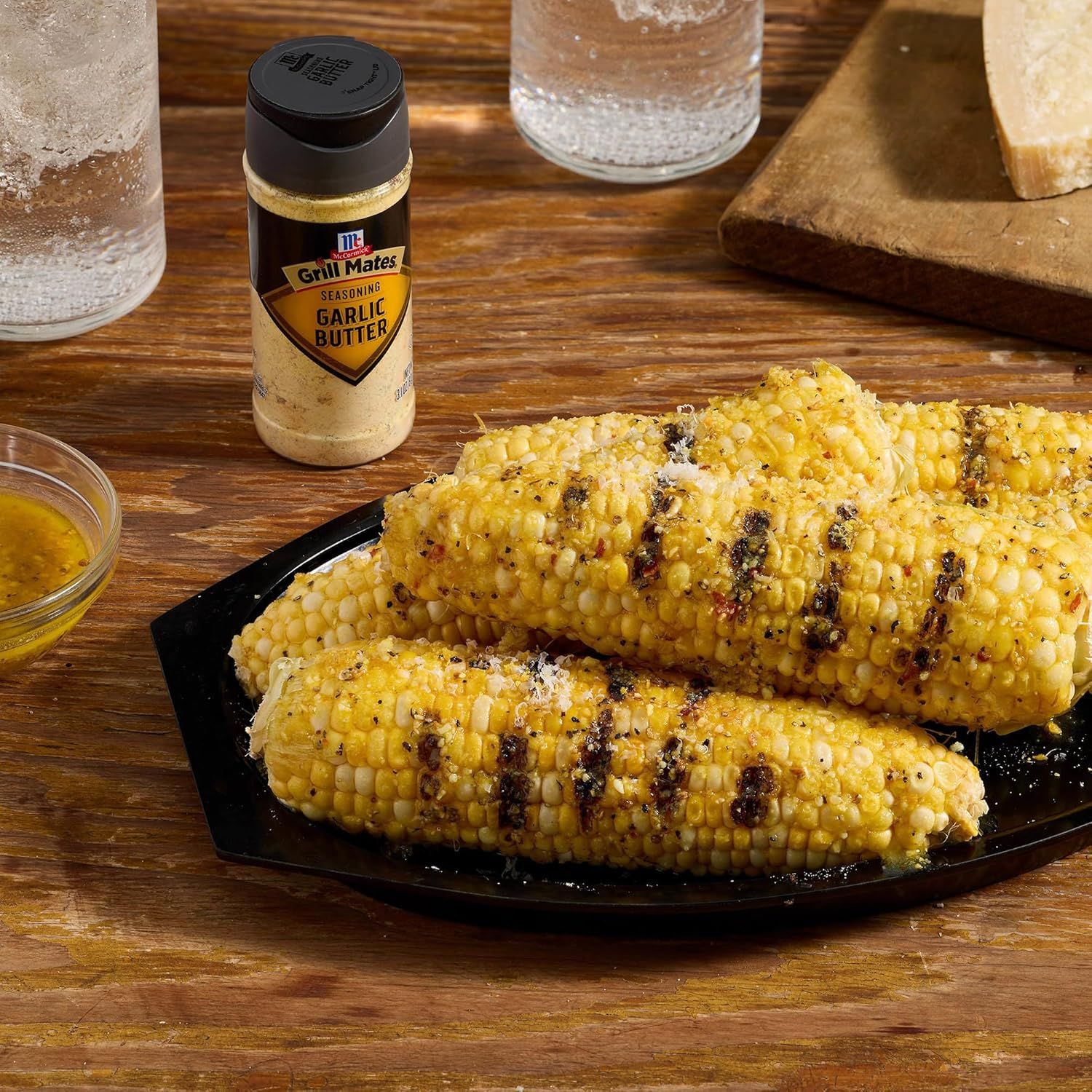 Demonstrates the product in a real-world grilling context, showing the finished result of seasoned grilled corn to help shoppers visualize how they can use the garlic butter seasoning.