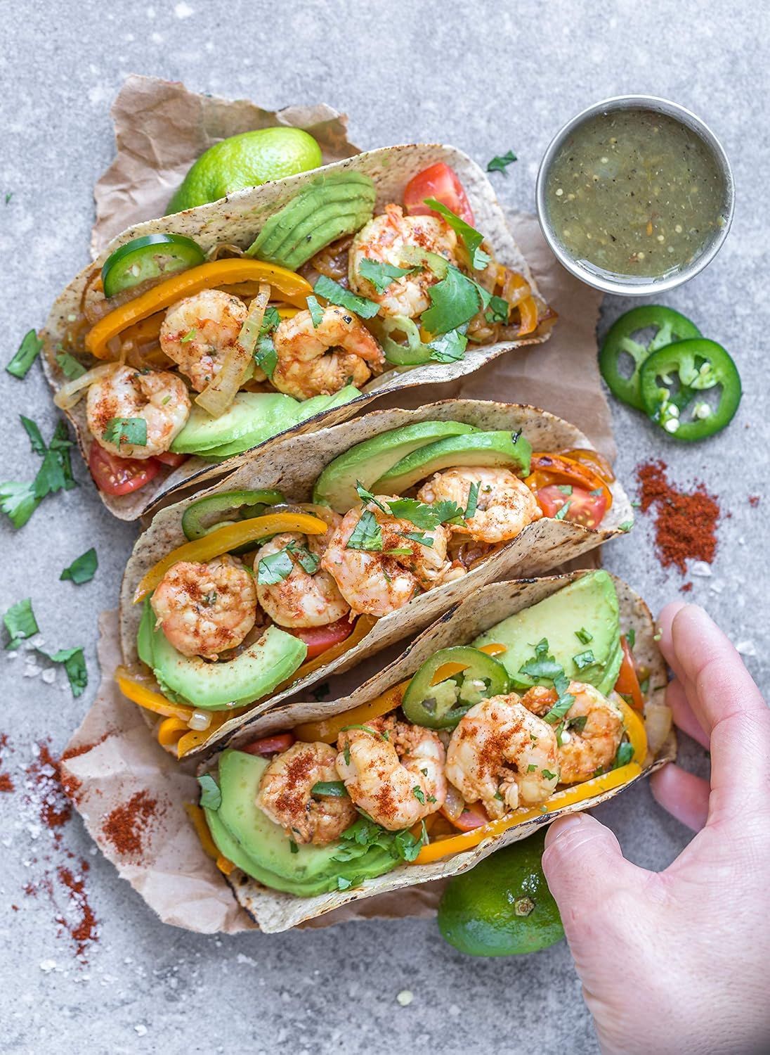 Showcases the product (shrimp tacos) in an authentic, appetizing real-world setting to help shoppers visualize the meal and create desire through beautiful food styling.