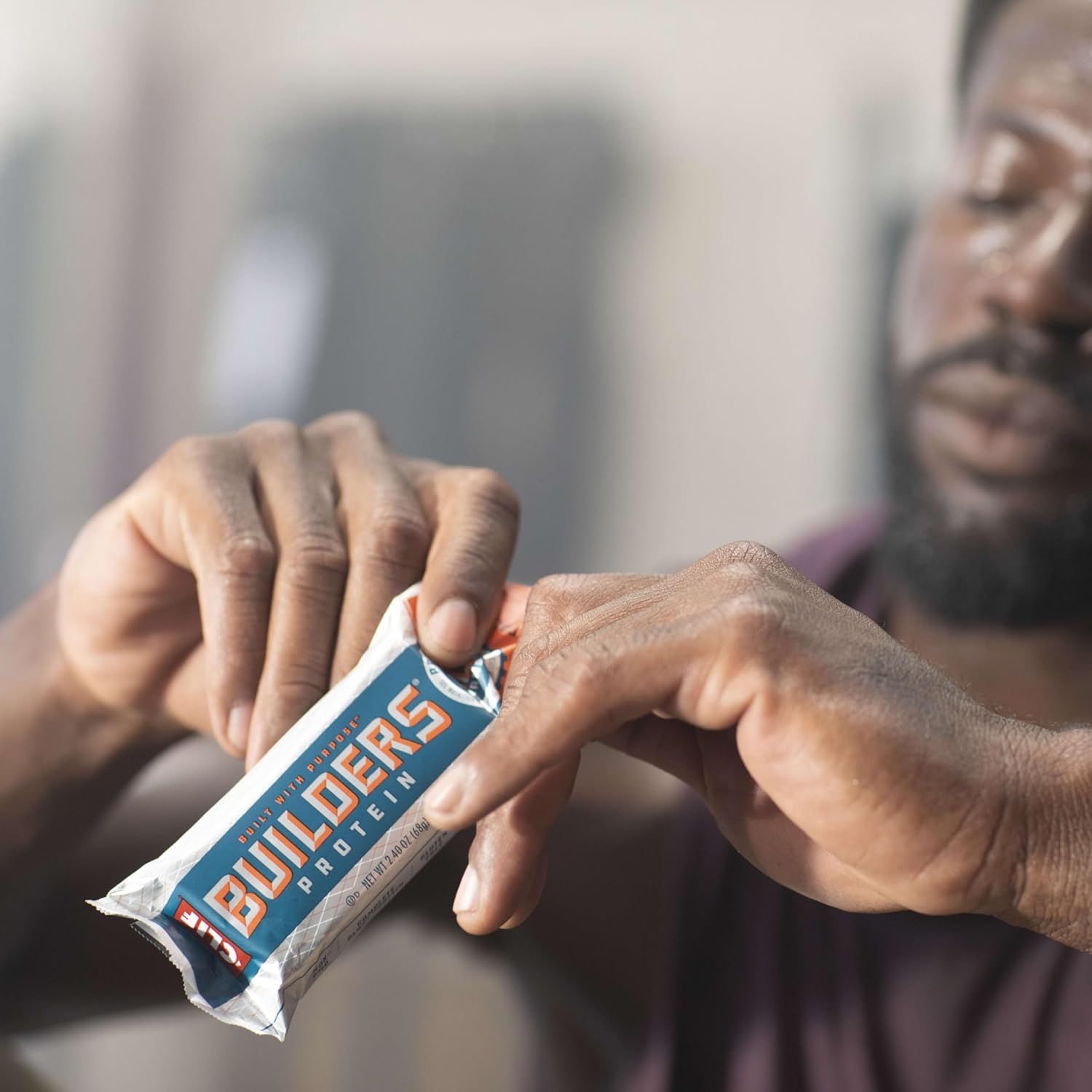 Shows the product being used in an authentic, everyday setting to help shoppers visualize themselves using the protein bar in their daily routine.