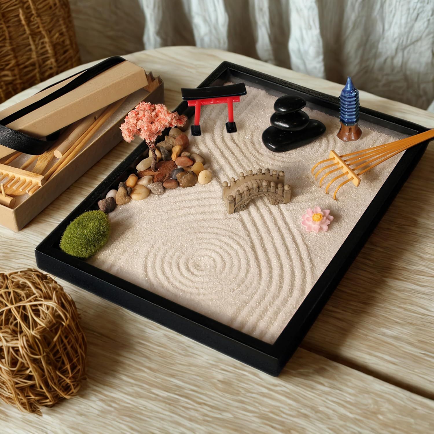Shows all the components included in the zen garden kit—sand tray, rakes, decorative elements (torii gate, stones, bridge, pagoda, trees, flowers)—to help shoppers understand the complete set they…