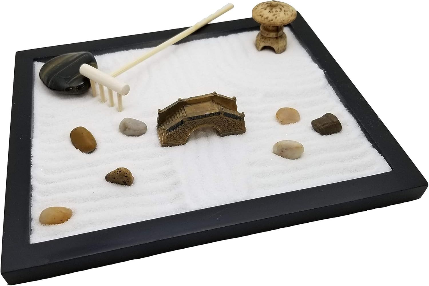 Shows all the components included in the zen garden set, helping shoppers understand they receive a complete kit with sand, rake, decorative elements, and accessories.