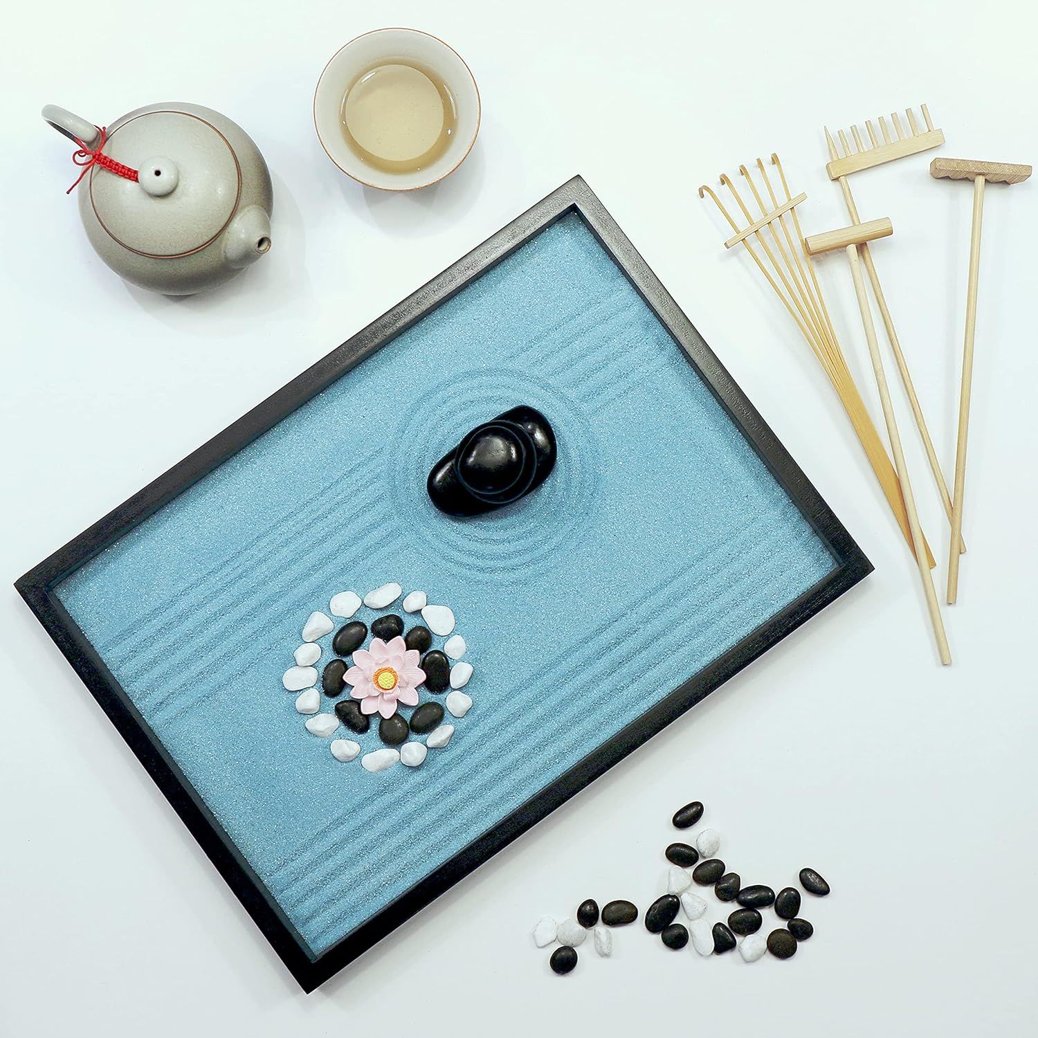 Shows all the items included in the zen garden kit to help shoppers understand the complete set they will receive, including the sand tray, stones, rakes, teapot, and decorative elements.