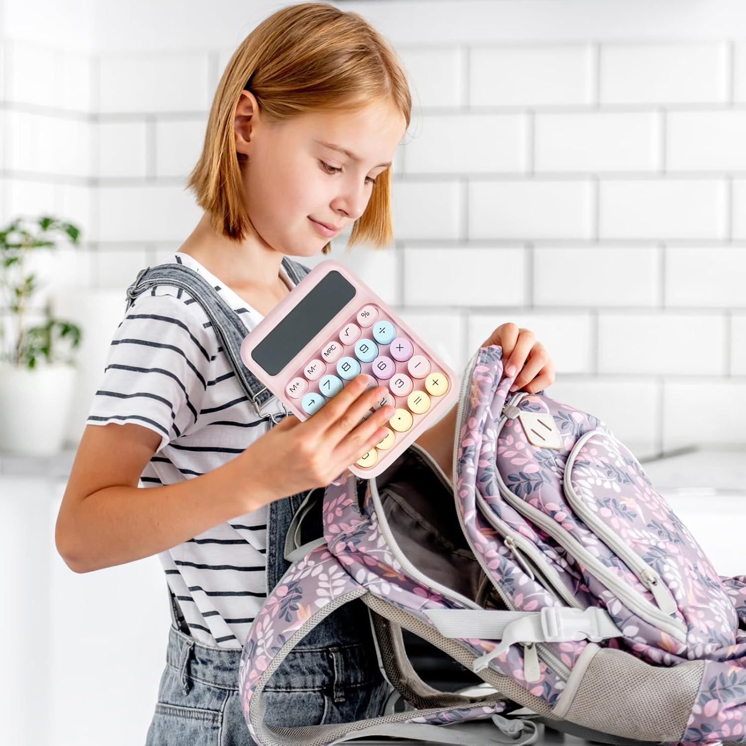Demonstrates the product in a real-world context showing a child using the calculator with their school backpack, communicating that the product is practical and suitable for students.