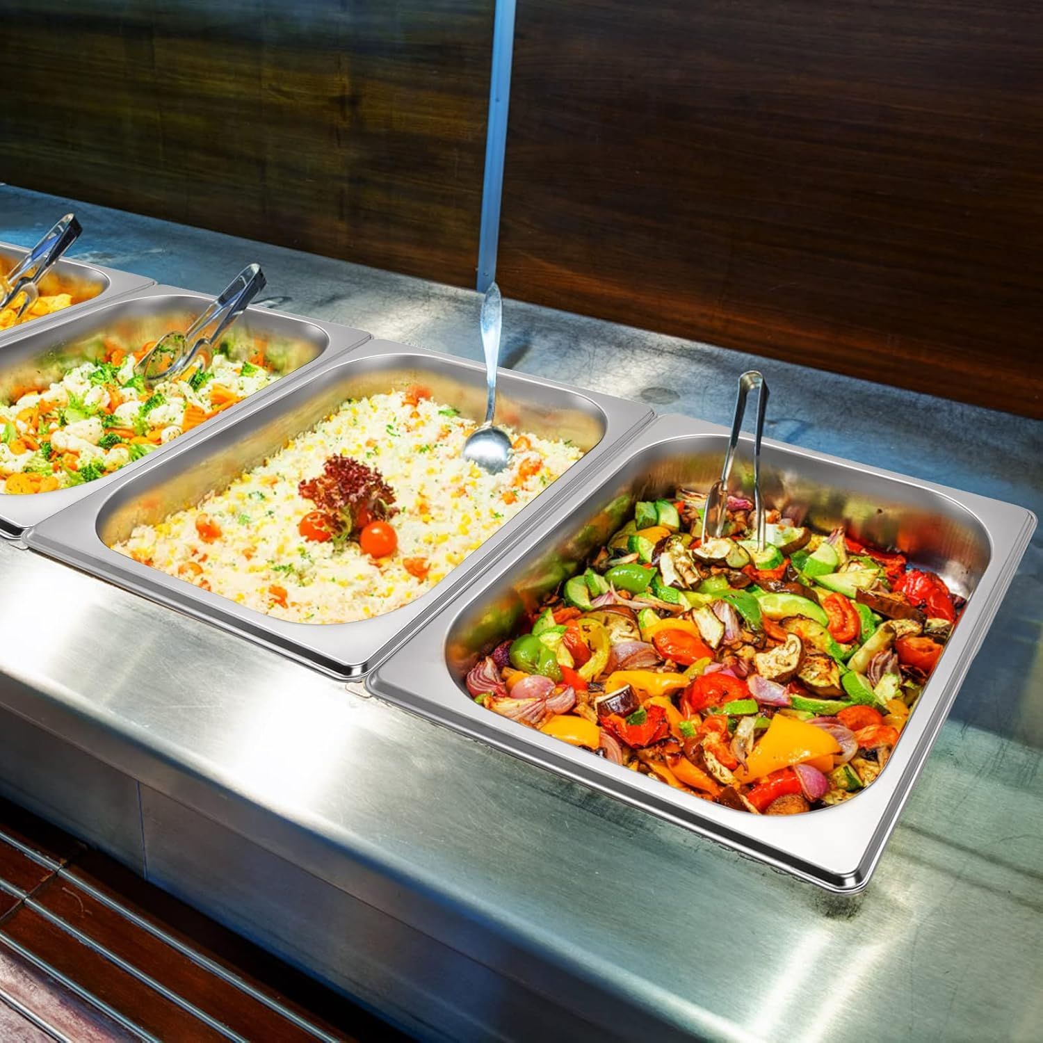 Demonstrates the product in a real-world buffet or catering context, showing how the food warmer holds multiple dishes with serving utensils in an attractive, functional setup.