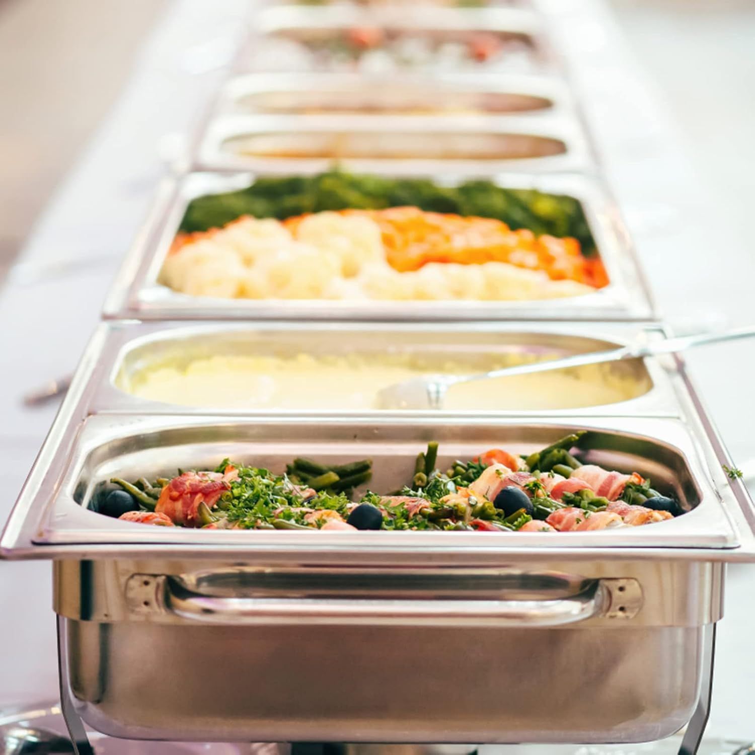 Demonstrates the product in a real-world catering or food service setting, showing how the chafing dish/food warmer holds and presents multiple dishes attractively.
