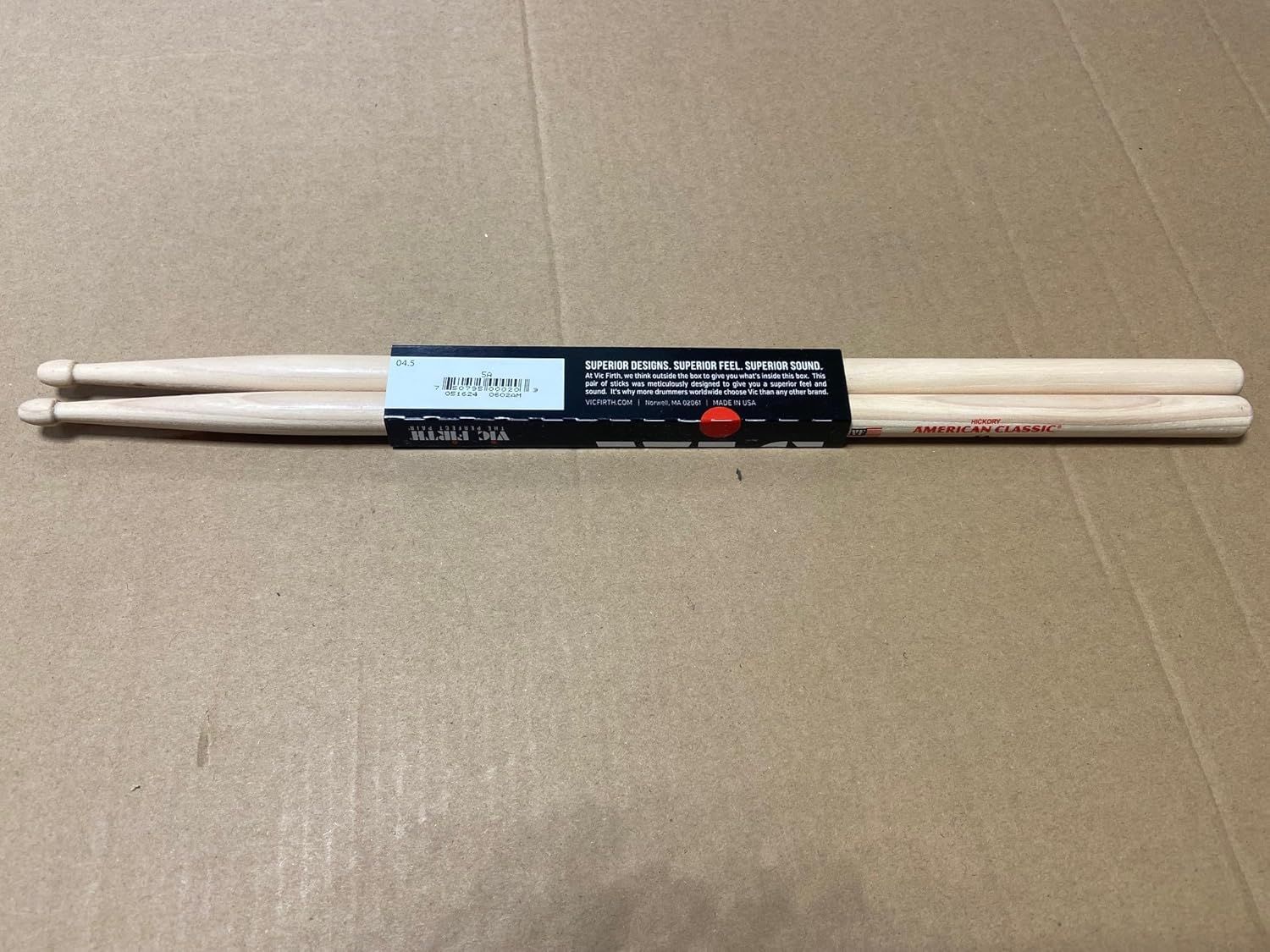 Shows the customer what is included in the package - a pair of drumsticks with product labeling and branding visible, demonstrating the complete purchase.