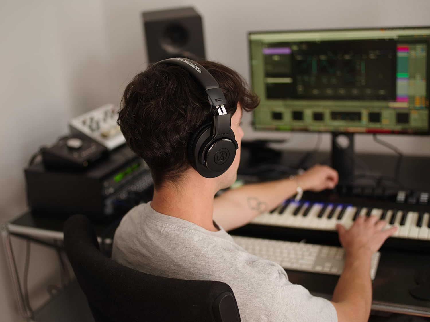 Demonstrates the product in a real-world music production setting to help shoppers visualize using the headphones for professional audio work and creative applications.