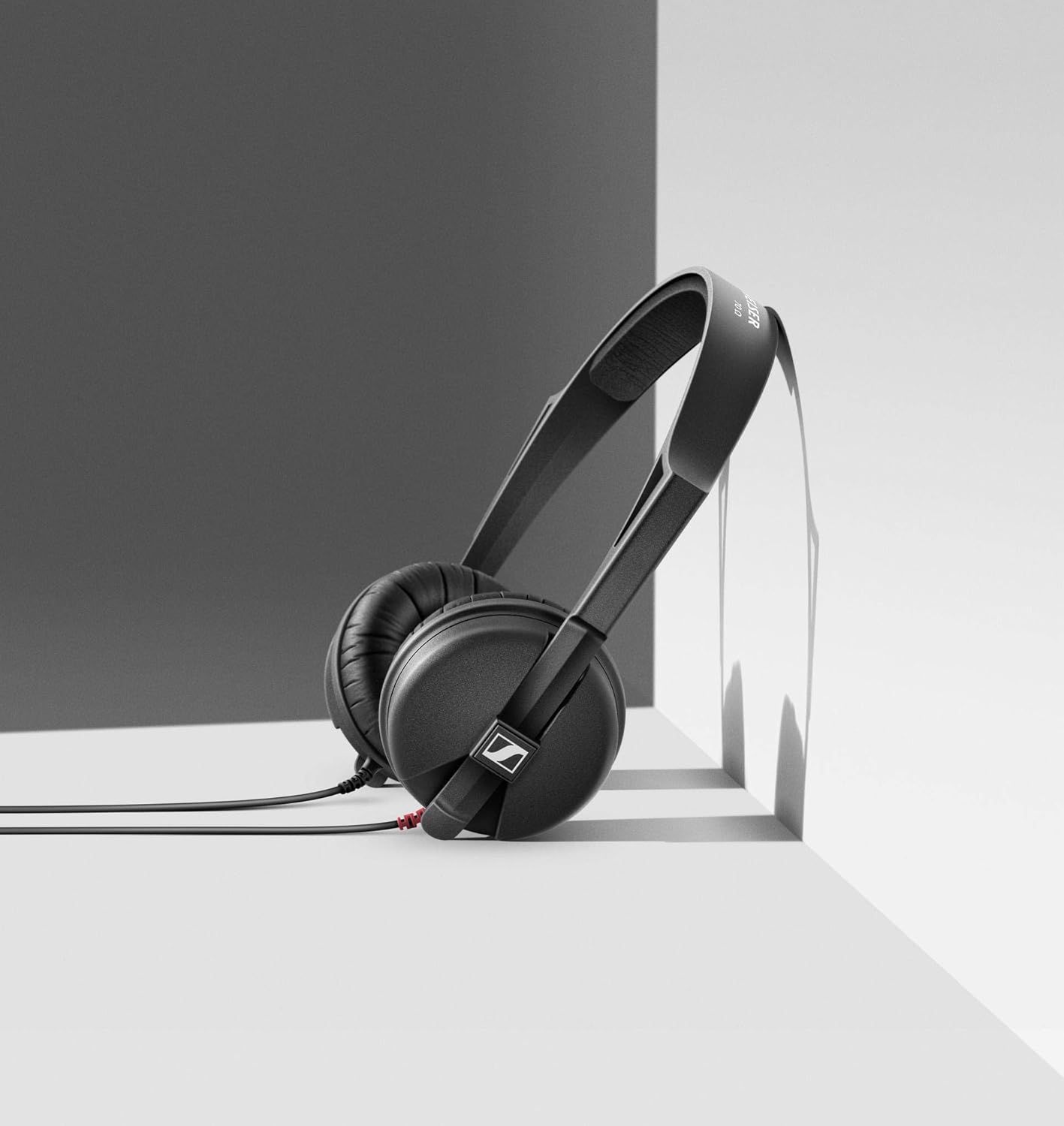 Showcases the headphones in an artistic, minimalist studio setting to convey premium quality and modern design aesthetics.