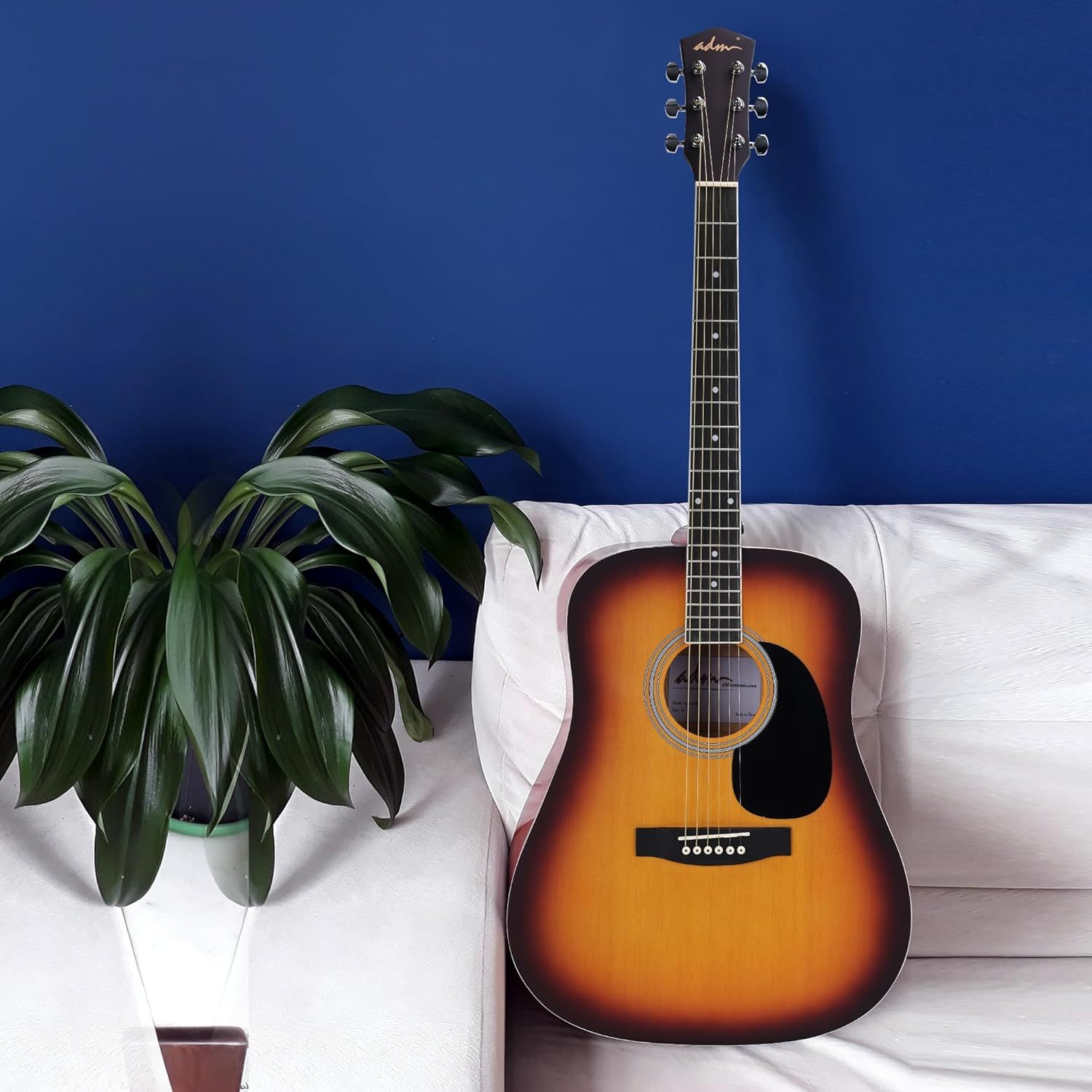 Shows the guitar in a real-world home environment to help shoppers visualize the product in their own living space and create an emotional connection.